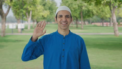 happy muslim man saying hello in park