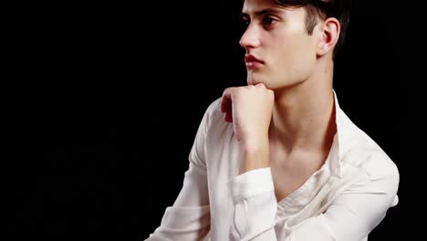 Androgynous-man-posing-against-black-background