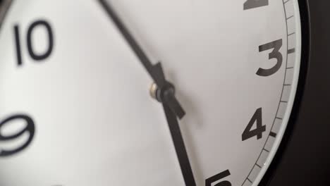 white clock face close up in time lapse on dark grey wall