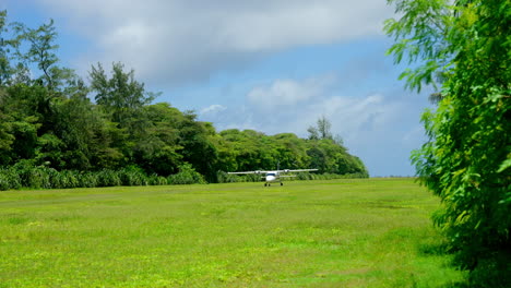 Weitwinkelaufnahme-Eines-Kleinen-Charterflugzeugs,-Das-Auf-Einer-Landebahn-Mit-Grünem-Gras-Landet