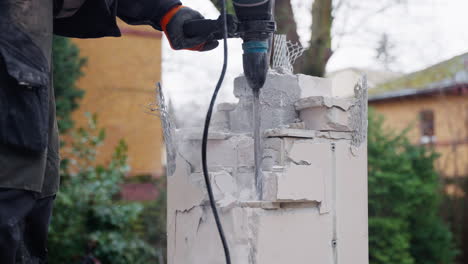 Man-Using-Jackhammer-to-Demolish-Brick-Wall---close-up-slow-motion