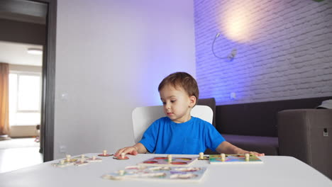 adorable caucasian baby boy sitting peacefully at the desk. lovely toddler playing and studying.
