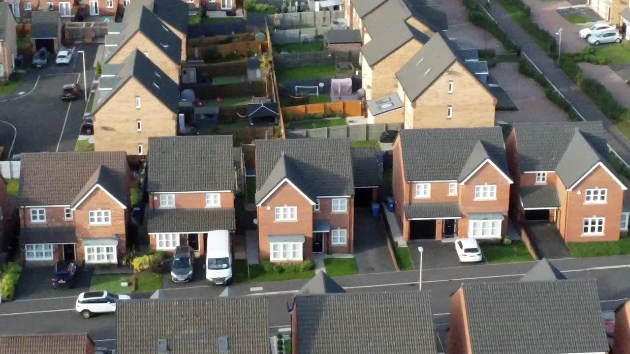 Property ladder new British housing estate aerial view overlooking rooftops left dolly Birdseye