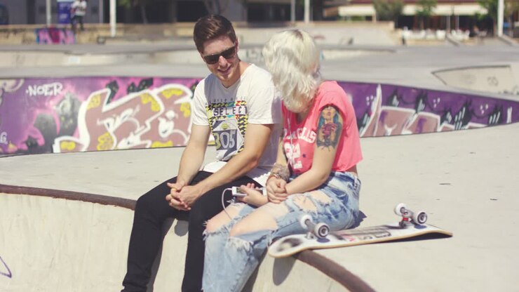 Man chatting to his girlfriend at a skate park