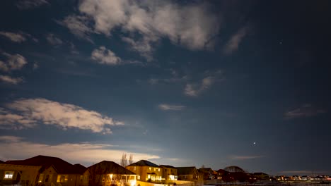 Nächtliche-Wolken,-Sterne-Und-Strahllichtspuren-über-Einem-Vorstadtviertel-–-Zeitraffer