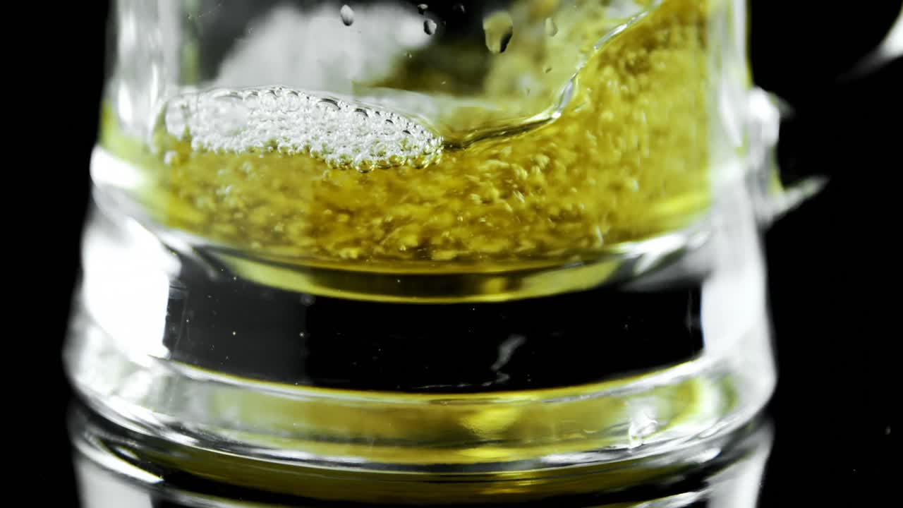 Beer poured in beer mug against black background 4k