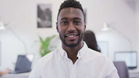 Portrait-of-smiling-african-american-businessman-looking-at-camera-in-modern-office