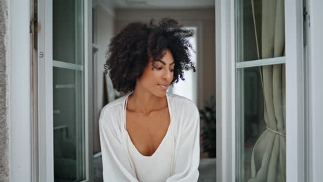 Mujer-Africana-Mirando-Por-La-Ventana-En-Casa-De-Cerca.-Chica-Rizada-Mirando-Retrato-De-Cámara