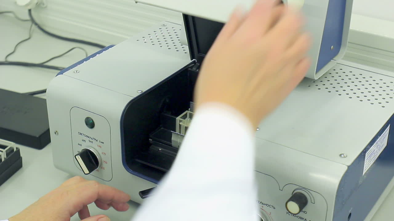 Scientist puts sample into test equipment close cover. Modern equipment