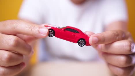 Young-Asian-woman-holding-red-car-model-concept-for-travel-Insurance-concept