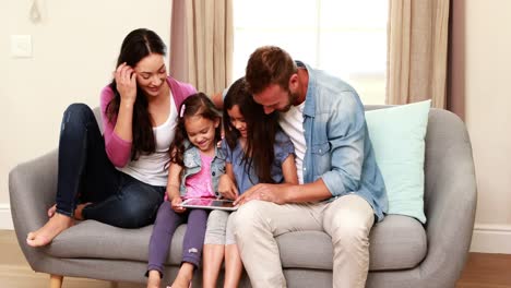 Familia-Feliz-Usando-Tableta-En-El-Sofá