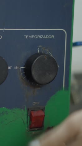 a hand adjusting a timer dial on a control panel