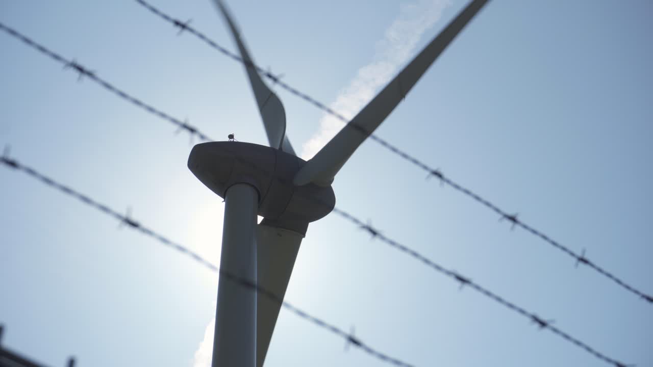 배경에 풍력 터빈이 있는 강철 울타리 철조망