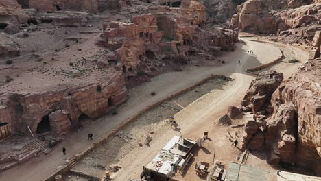 drone shot following a person riding through a ancient city ruins in wadi rum, jordan