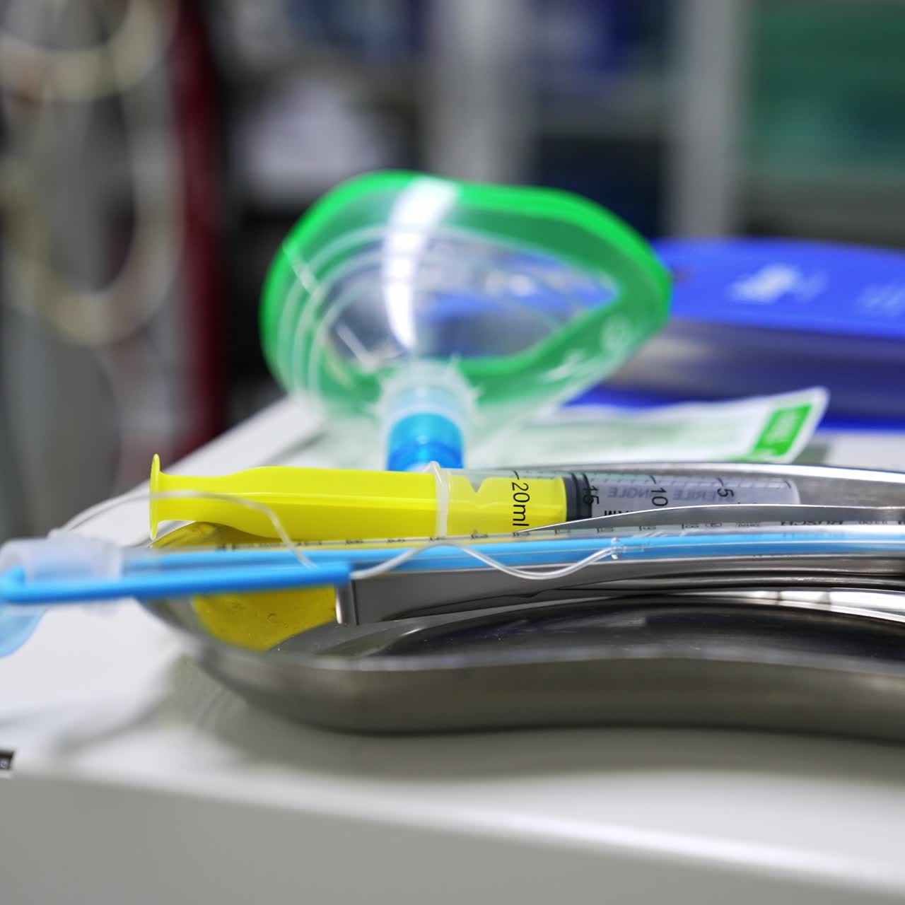 Tools, instruments and oxygen mask placed on the metal tray. Medical appliances lying on the equipment in surgery room. Close up. Blurred backdrop