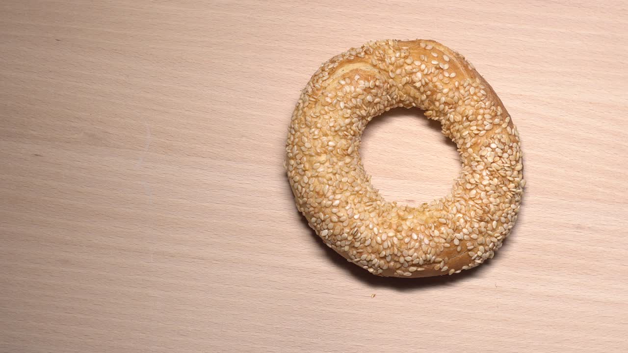 bagels frescos con semillas de sésamo en rotación. en la tabla de cortar de madera. primer plano extremo.