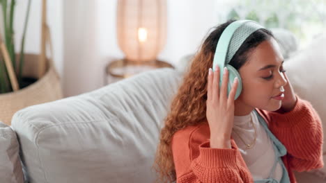 woman relaxing on a sofa with headphones