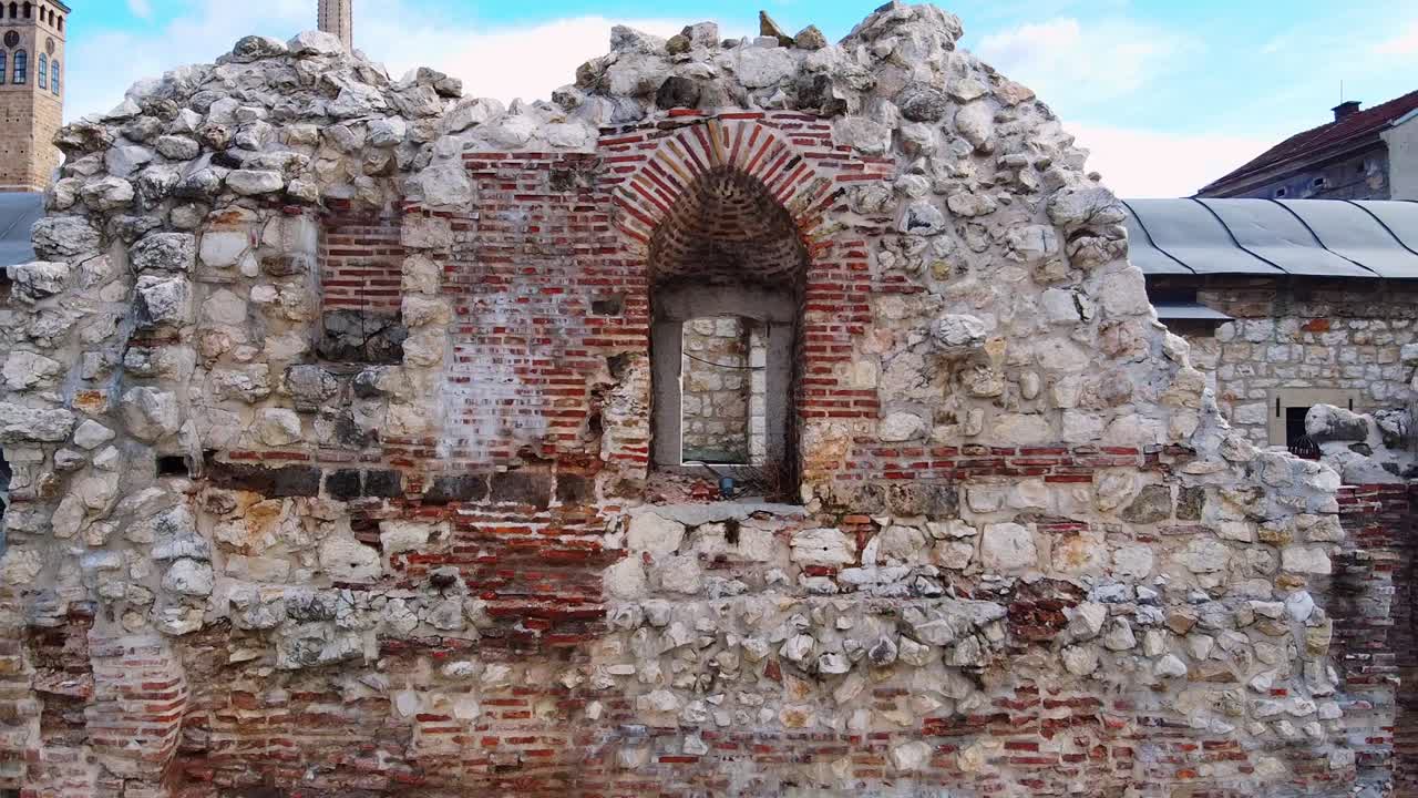 카메라와 함께 드론은 사라예보의 고대 taslihan caravanserai의 폐허 벽의 폐허 창문에서 멀리 날아갑니다.
