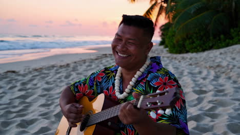 man playing guitar on a beach at sunset