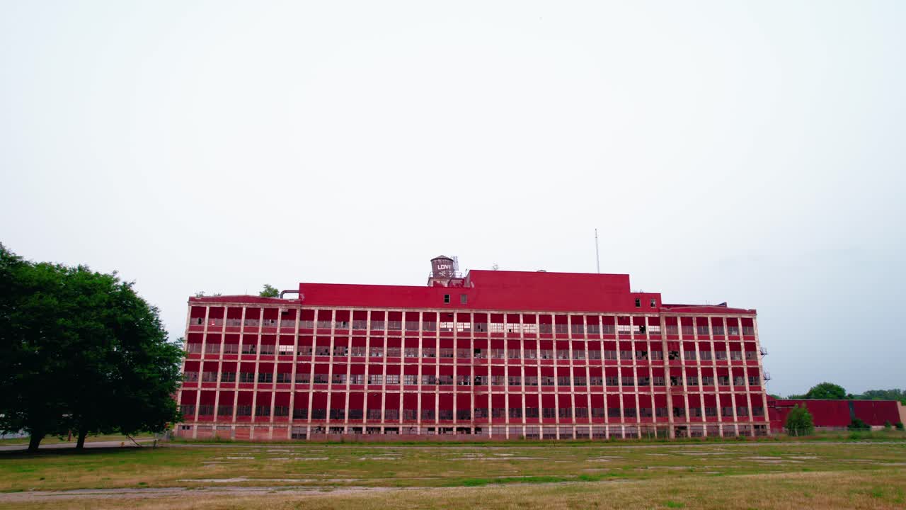 강한 대칭성과 패턴을 가진 극적인 빨간색 버려진 건물의 공중에서 지상으로 낮은 각도로