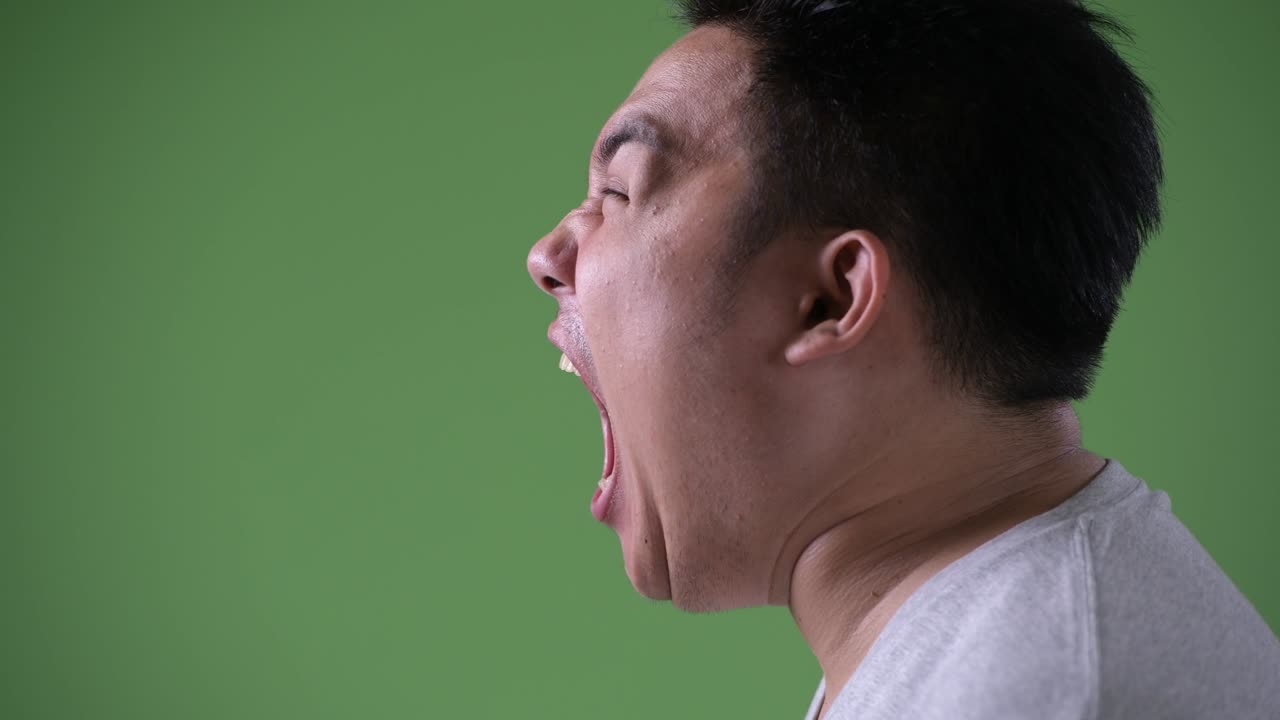 초록색 배경에 젊은 잘생긴 과체중 아시아인