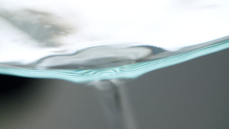 abstract macro shot of water dropping out of a glass