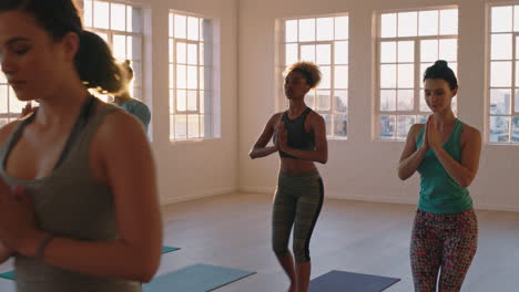 Clase-De-Yoga-De-Jóvenes-Sanos-Practicando-Pose-Guerrera-Instructora-Mujer-Enseñando-A-Grupos-Diversos-Disfrutando-Del-Estilo-De-Vida-Físico-Haciendo-Ejercicio-En-El-Estudio-Al-Amanecer.