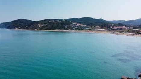 Bahía-De-La-Isla-Griega,-Vista-Aérea-De-Drones-De-Personas-Nadando-Y-Tomando-El-Sol-En-La-Playa-En-San-Stefanos-Corfú