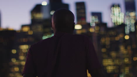 Rear-View-Of-Friends-Looking-At-Manhattan-Skyline-At-Sunset