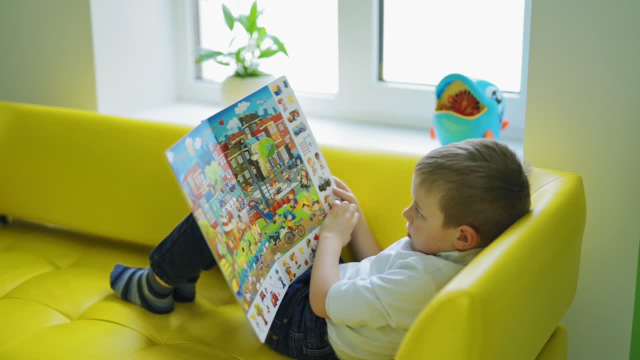 Anak laki-laki kecil dengan buku. Anak laki-laki kecil yang menarik, muda, dan ceria dengan buku.