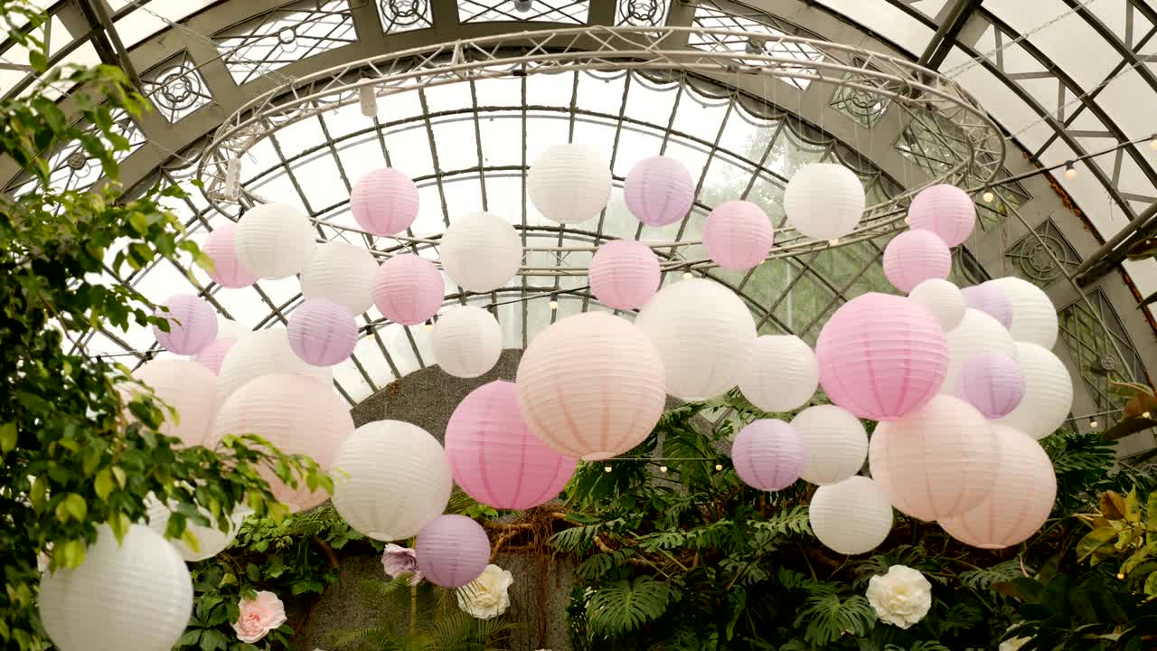 bolas rosadas blancas de papel de arroz colgando de las ramas de los árboles verdes