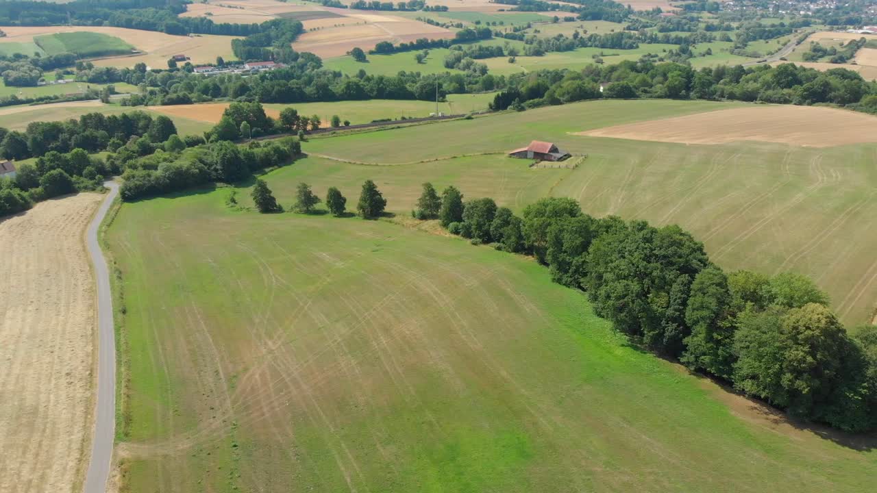 drone volando sobre tierras de cultivo con cobertizo