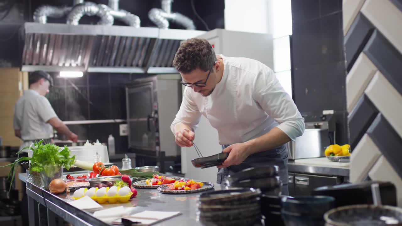 Chef Serving Tomato Salad on Plate in Restaurant Kitchen