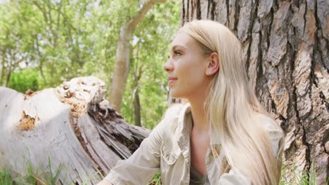 happy caucasian woman sitting and admiring nature in park, slow motion