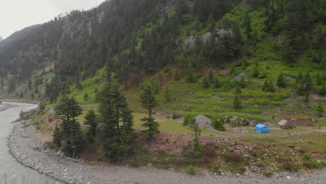 aerial over swat river with campsite on riverbank in kalam valley in pakistan