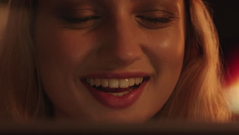retrato de cerca de una mujer hermosa usando una tableta viendo una película riendo disfrutando de entretenimiento cómico relajándose en casa
