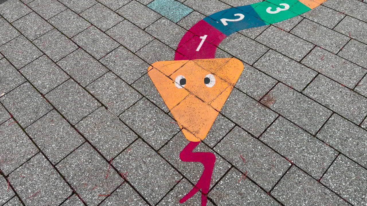 A children's game is painted on the floor, numbers can be seen in the painted snake, tilt up shot