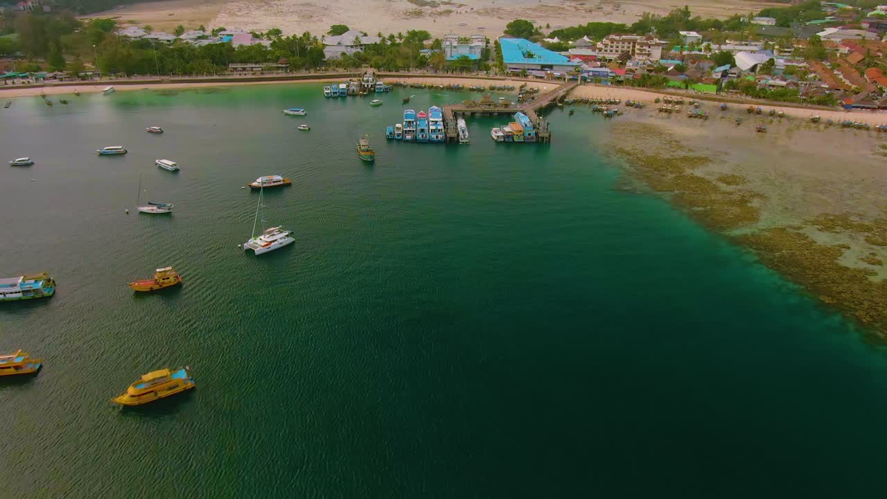 vista aérea de un puerto de una isla tropical con barcos y resorts