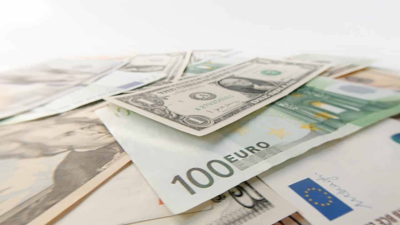 Sich drehende Dollar- und Euro-Banknoten verschiedener Nennwerte, Nahaufnahme. Hintergrund aus rotierenden Dollar- und Euro-Scheinen. 4K Makro-Rohvideo 60 fps