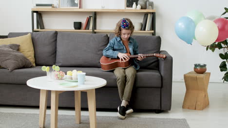 niño con sombrero de fiesta tocando música