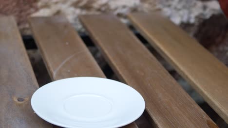 empty white saucer on wooden table