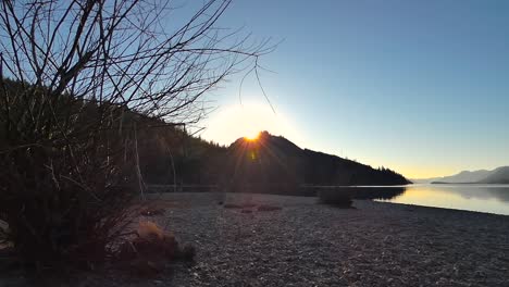 sunset on a lake with mountains in background