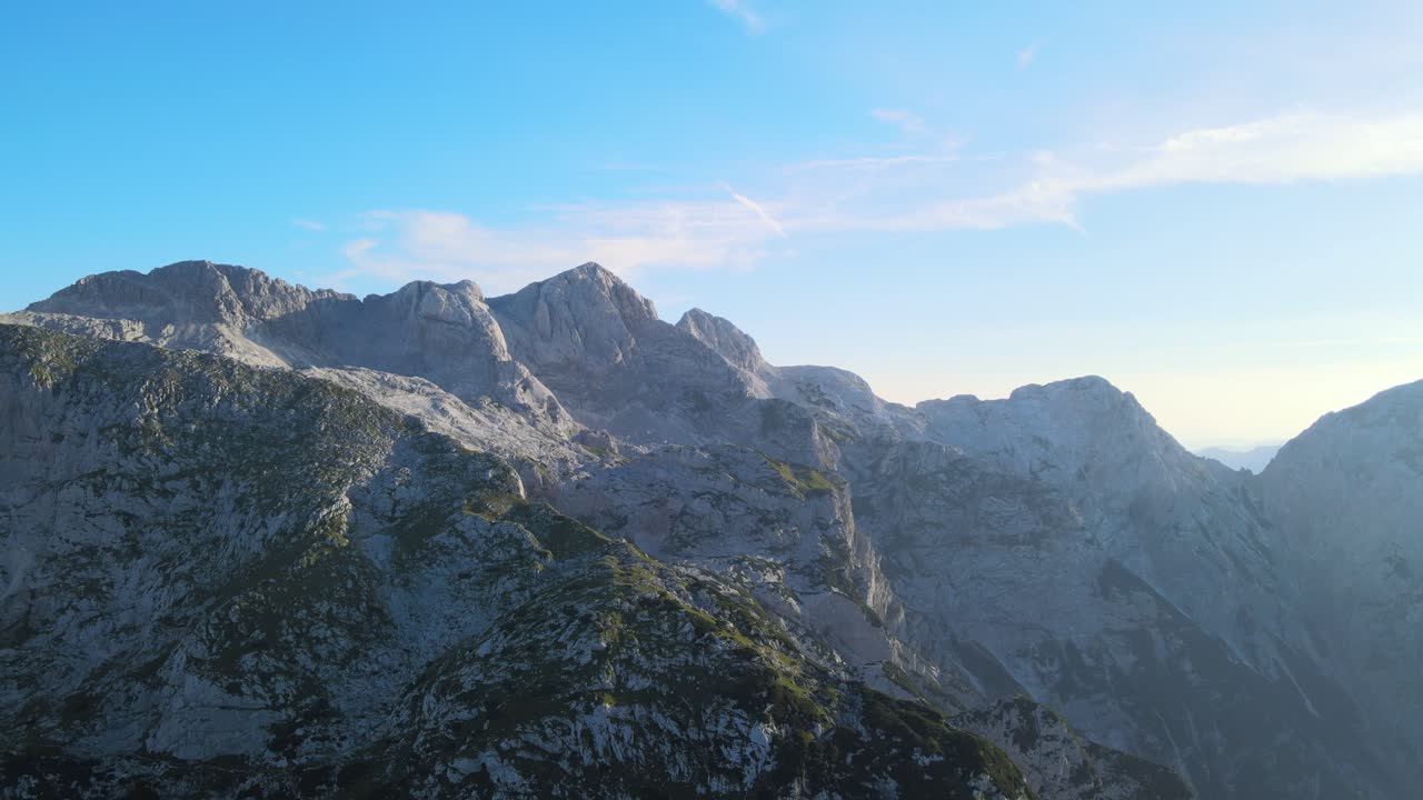 Stunning aerial footage of a mountain range at sunrise with clear skies