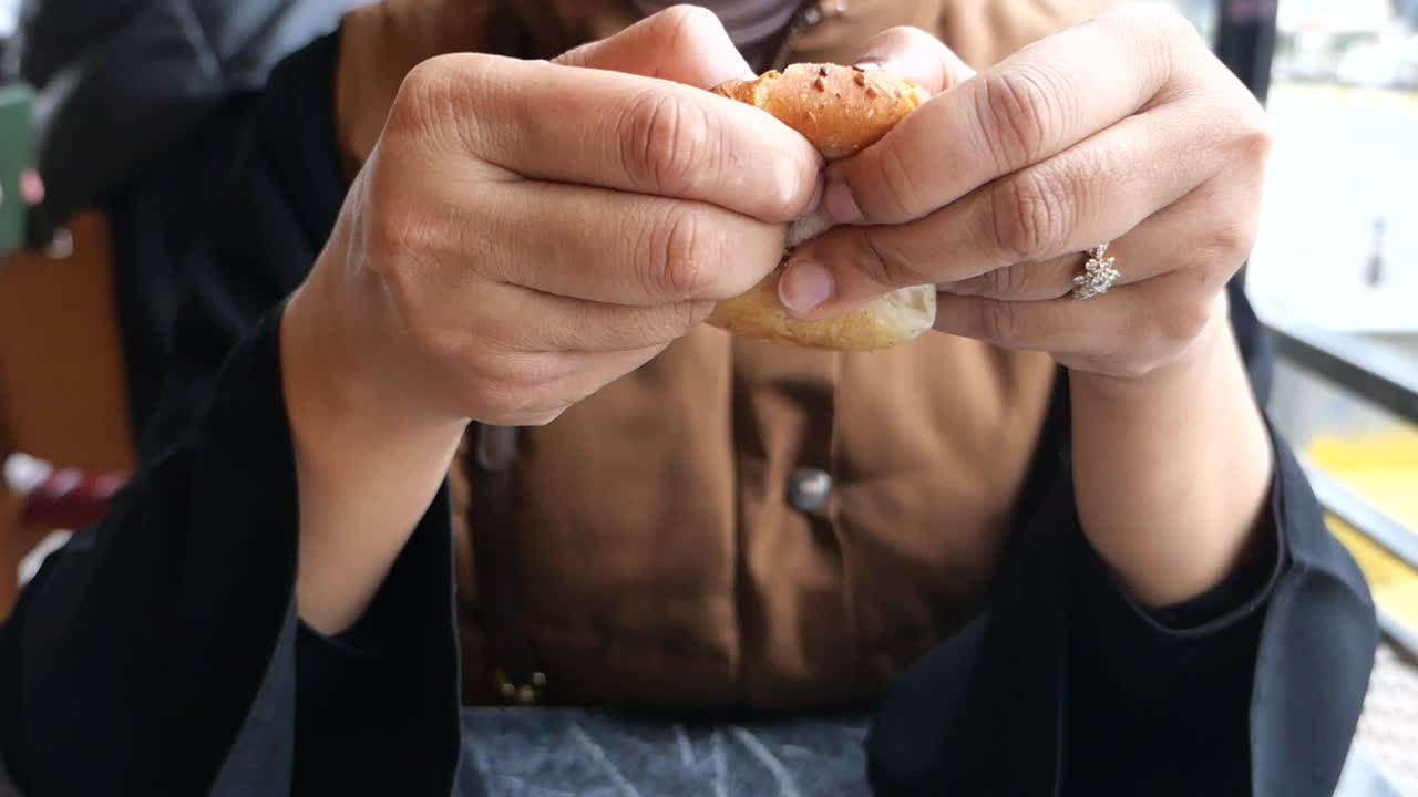 una mujer comiendo un bagel.