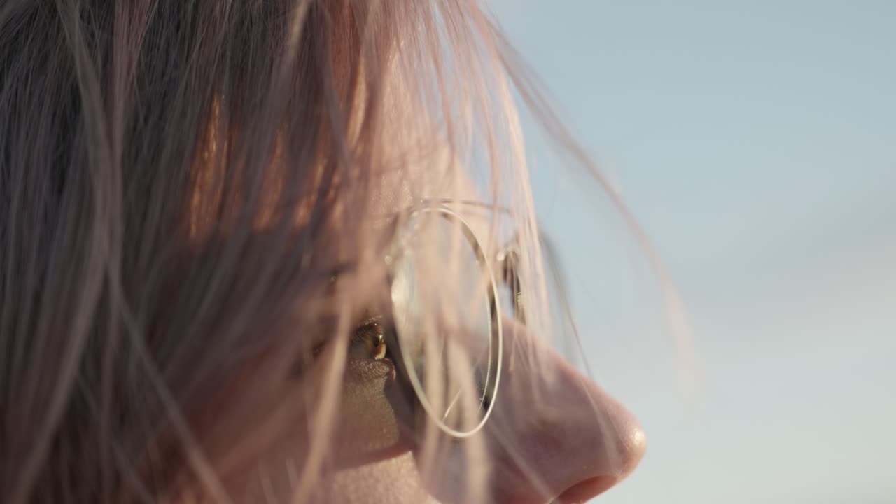 바람이 불는 저녁에 선글라스를 입은 여성의 느린 움직임