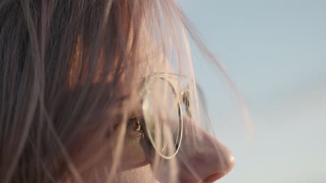 Slow-motion-of-woman-with-sunglasses-on-windy-evening