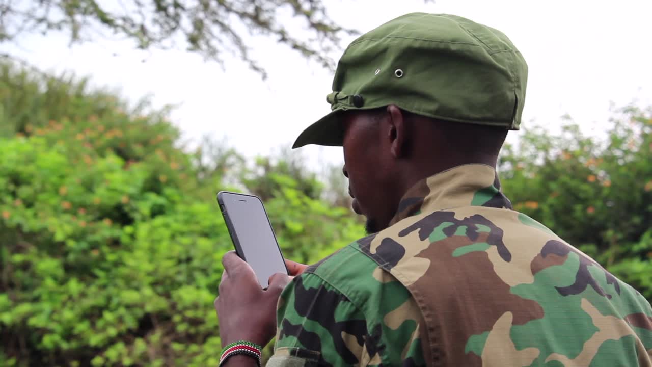 Militante guerrigliero africano che usa il suo cellulare.