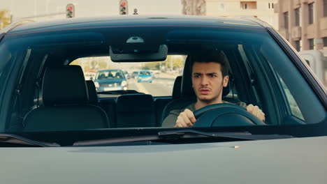 a young man driving a car with a surprised expression
