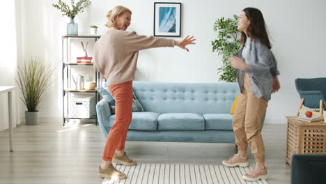 madre e hija bailando en casa
