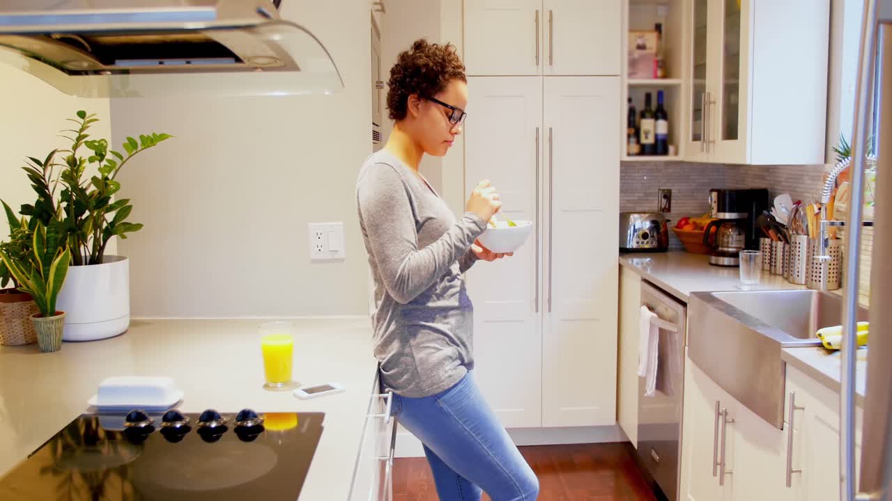 Woman having breakfast in kitchen 4k